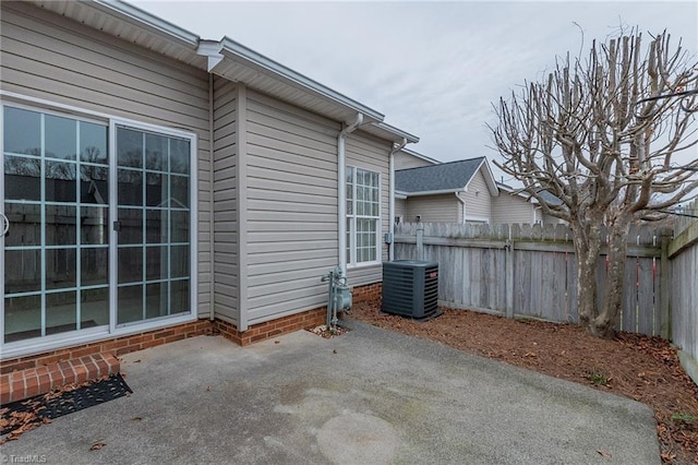 view of patio with cooling unit and fence