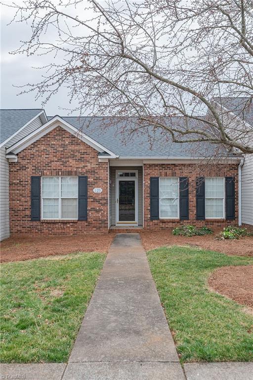 single story home featuring a front lawn, brick siding, and a shingled roof