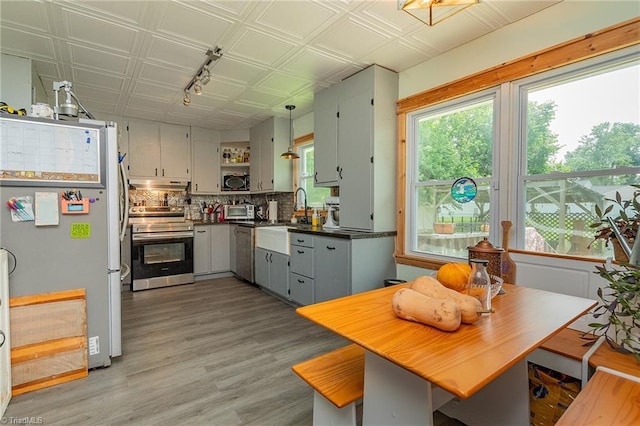 704 Summit Rd, High Point, NC 27265 - kitchen featuring appliances with stainless steel finishes, open shelves, dark countertops, under cabinet range hood, and track lighting