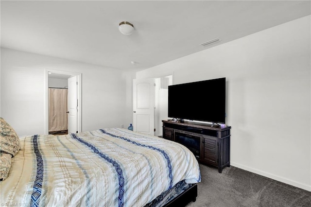 bedroom with ensuite bathroom and carpet flooring