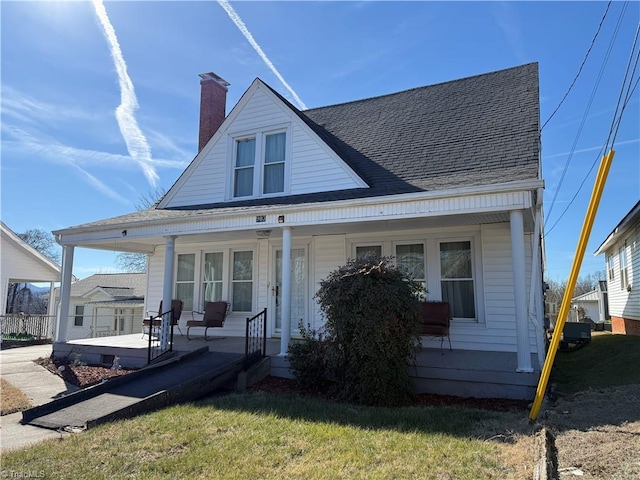 bungalow featuring covered porch and a front lawn