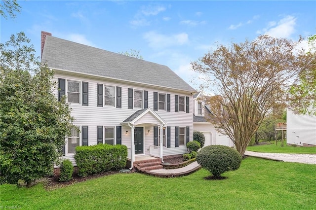 colonial home with a chimney and a front lawn