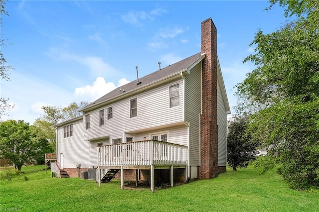 back of property featuring a chimney, a wooden deck, and a yard