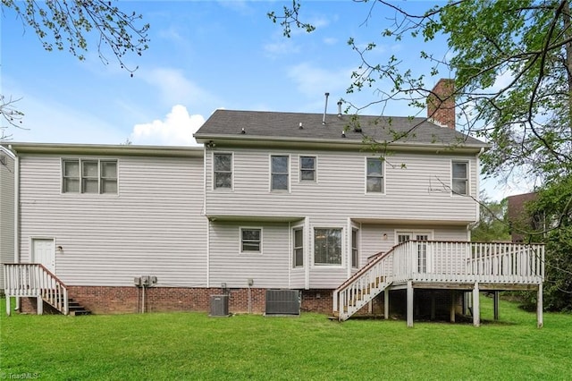 back of house with stairway, a deck, a lawn, and a chimney