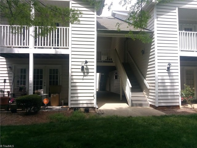 rear view of house with stairs and a balcony
