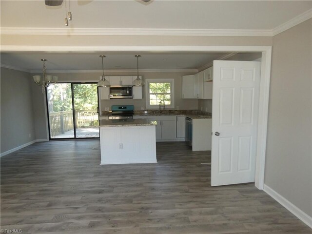 kitchen featuring sink, appliances with stainless steel finishes, decorative light fixtures, dark hardwood / wood-style flooring, and white cabinetry