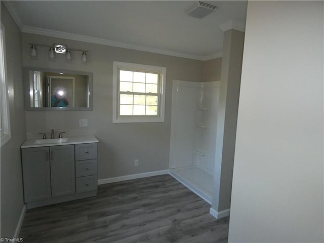 bathroom with hardwood / wood-style floors, vanity, and ornamental molding