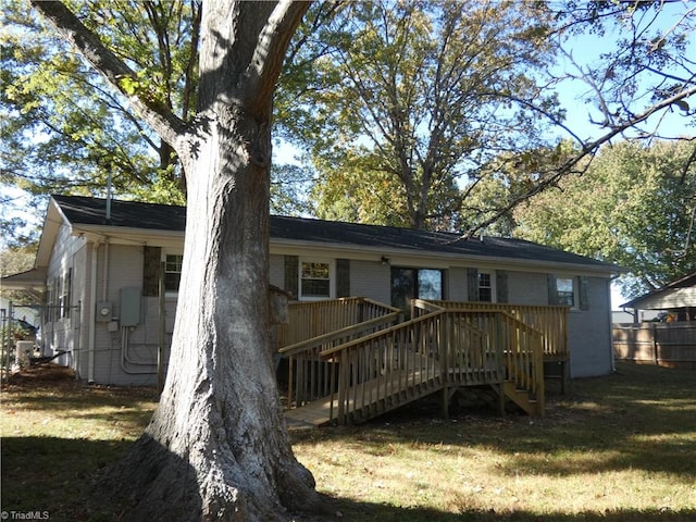 rear view of property with a lawn and a wooden deck