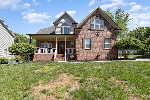 view of front of property featuring a porch, a front lawn, and brick siding