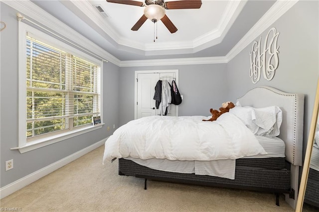 bedroom featuring crown molding, baseboards, a closet, carpet, and a tray ceiling