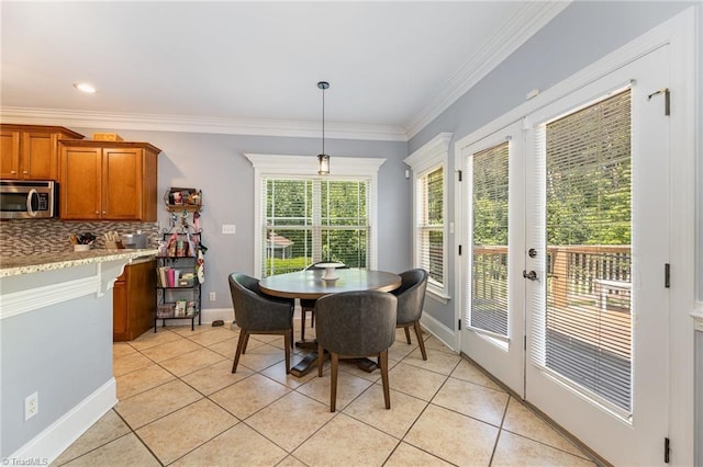 dining area with crown molding, light tile patterned flooring, baseboards, and french doors