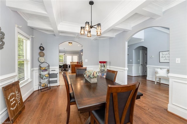 dining room with an inviting chandelier, arched walkways, beamed ceiling, and coffered ceiling