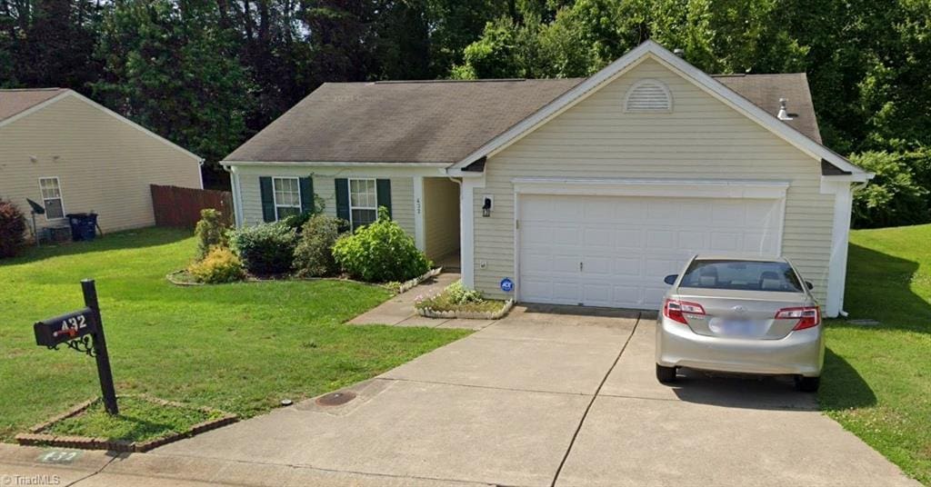 ranch-style home featuring a front yard, a garage, and driveway