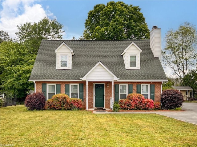 cape cod-style house featuring brick siding, a chimney, roof with shingles, and a front lawn