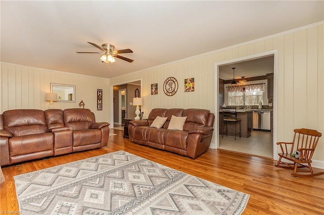 living room featuring ceiling fan, wood finished floors, and crown molding