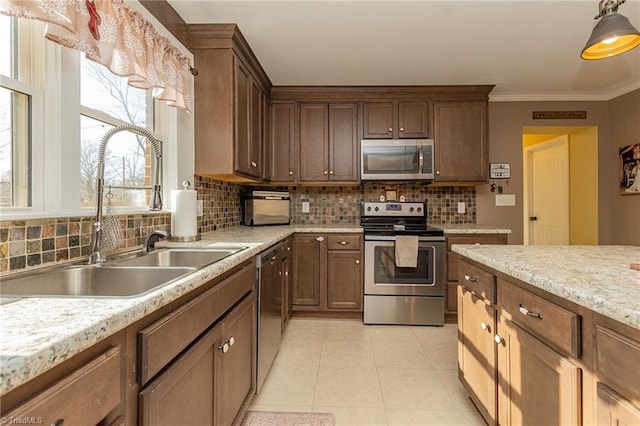 kitchen featuring light tile patterned flooring, a sink, light countertops, appliances with stainless steel finishes, and backsplash