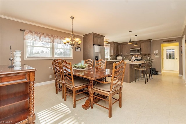 dining area with a chandelier, light tile patterned floors, crown molding, and baseboards