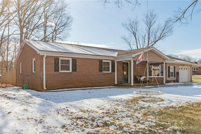 single story home featuring brick siding, a porch, and an attached garage