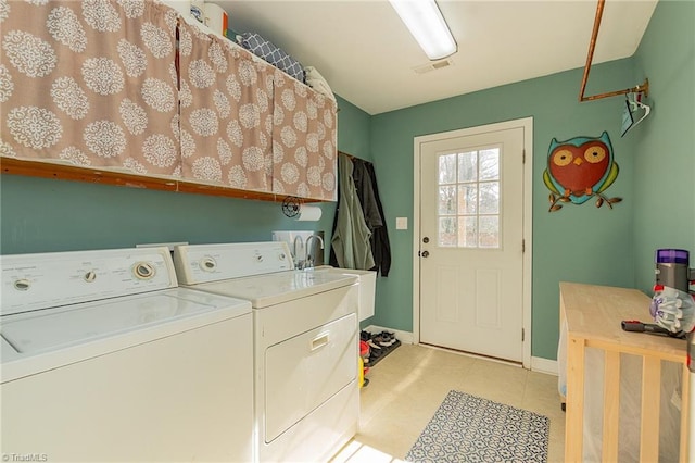 laundry area with visible vents, a sink, washing machine and dryer, cabinet space, and baseboards