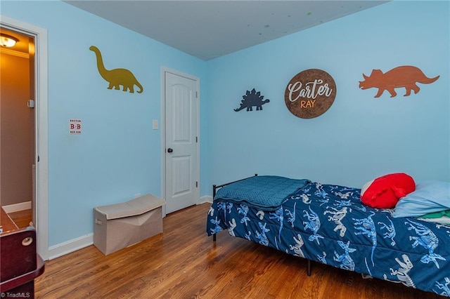 bedroom with baseboards and wood finished floors