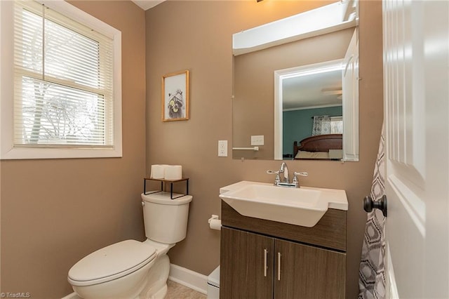 bathroom with vanity, toilet, baseboards, and ornamental molding