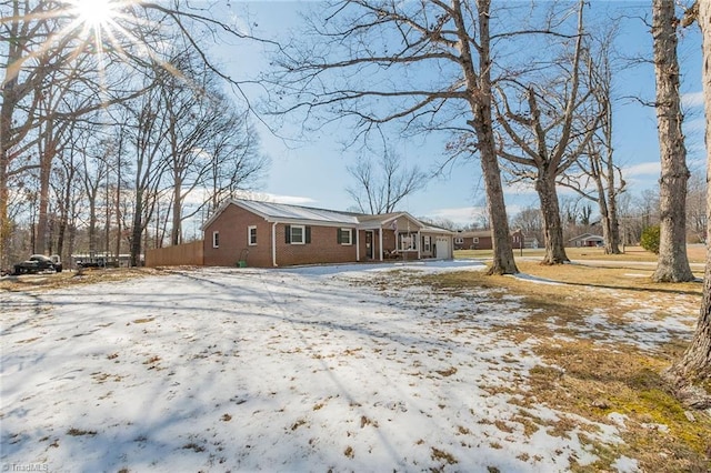 snow covered property with brick siding