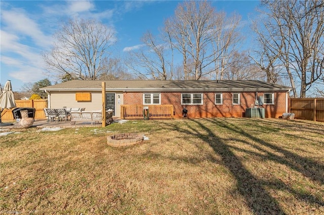 back of house featuring a patio, fence, a yard, a fire pit, and brick siding