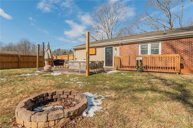 rear view of house with fence, an outdoor fire pit, a lawn, a patio area, and brick siding