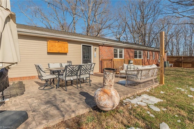 rear view of property featuring outdoor dining space, a patio, fence, and an outdoor hangout area