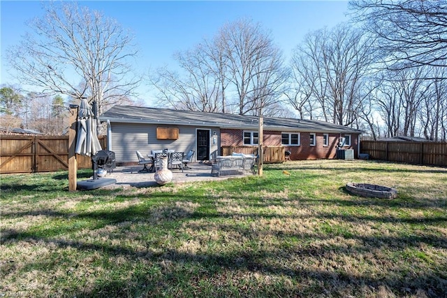 rear view of house featuring central AC unit, a fire pit, a lawn, and a fenced backyard