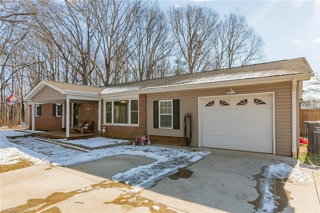 ranch-style house featuring fence, a porch, an attached garage, concrete driveway, and brick siding