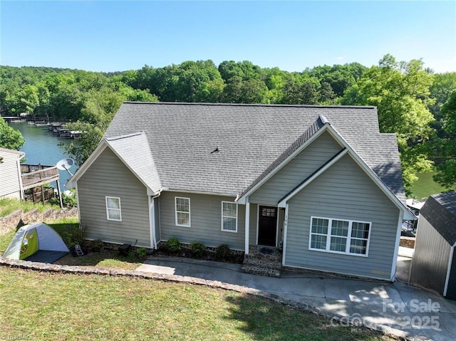 126 Strand Dr, New London, NC 28127 - single story home with a water view, a front yard, roof with shingles, and a wooded view