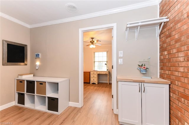 interior space featuring white cabinetry, crown molding, light hardwood / wood-style floors, and ceiling fan