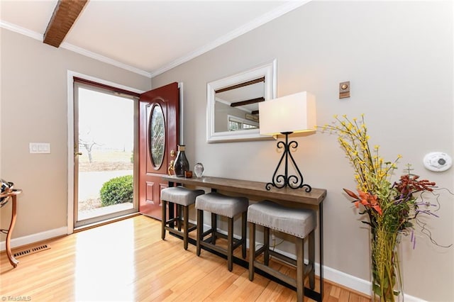 foyer entrance featuring crown molding and light hardwood / wood-style flooring