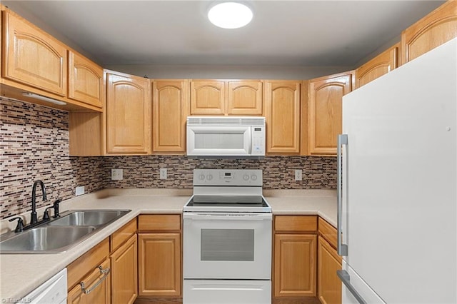 kitchen with light countertops, backsplash, light brown cabinetry, a sink, and white appliances