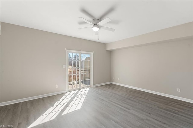 empty room with ceiling fan, baseboards, and wood finished floors