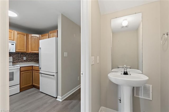 bathroom featuring tasteful backsplash, visible vents, baseboards, and wood finished floors