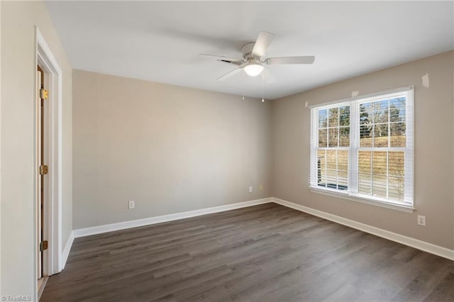 empty room featuring ceiling fan, dark wood-style flooring, and baseboards