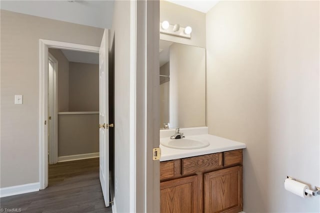 bathroom featuring vanity, baseboards, and wood finished floors