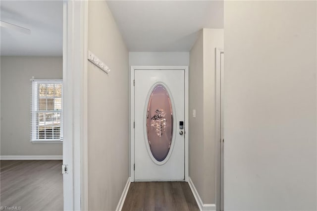 doorway featuring baseboards and wood finished floors