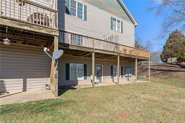 back of house with a patio area, a lawn, and a wooden deck