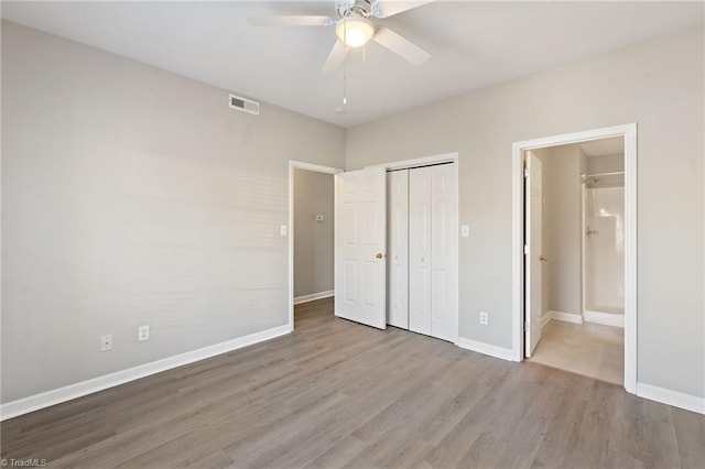 unfurnished bedroom featuring wood finished floors, visible vents, and baseboards