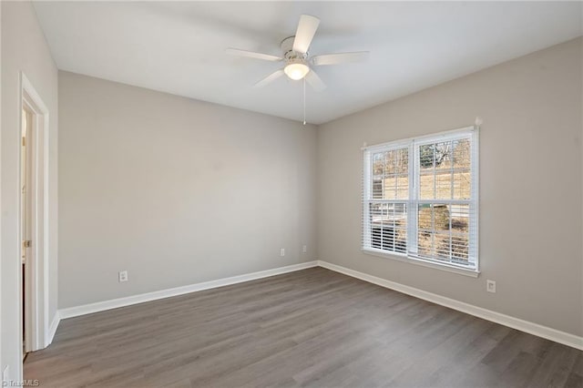 unfurnished room with dark wood-style floors, baseboards, and a ceiling fan