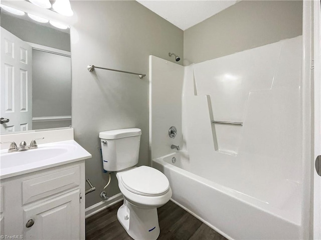 full bathroom featuring toilet, vanity with extensive cabinet space, hardwood / wood-style flooring, and tub / shower combination