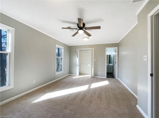 carpeted empty room featuring plenty of natural light, crown molding, and ceiling fan