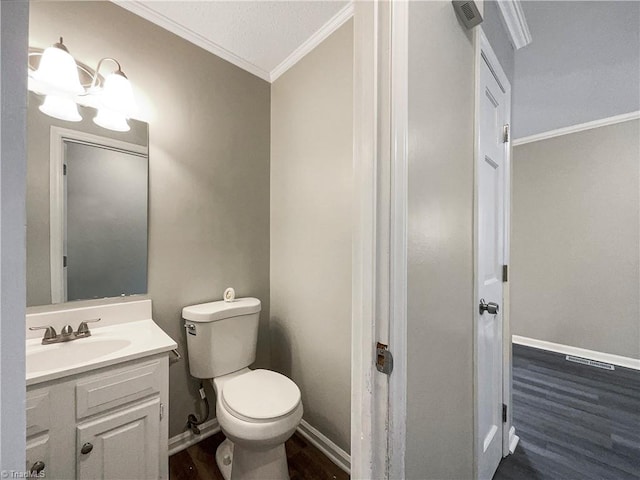 bathroom featuring hardwood / wood-style floors, a textured ceiling, toilet, vanity, and ornamental molding