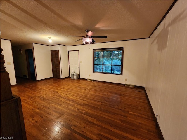 interior space featuring ceiling fan, crown molding, dark hardwood / wood-style floors, and a textured ceiling