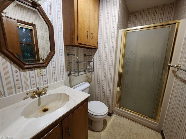 bathroom featuring walk in shower, vanity, and toilet