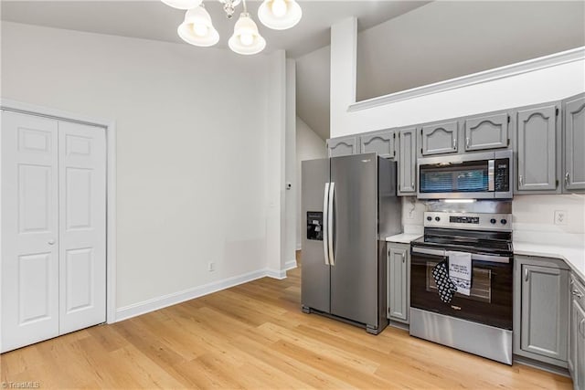 162 N Hazelwood Dr, Mocksville, NC 27028 - kitchen with appliances with stainless steel finishes, gray cabinetry, a chandelier, and vaulted ceiling