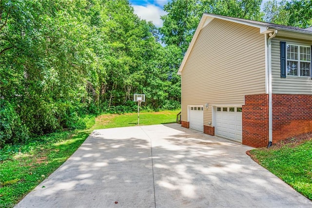 162 N Hazelwood Dr, Mocksville, NC 27028 - view of side of property with concrete driveway, an attached garage, a yard, and brick siding
